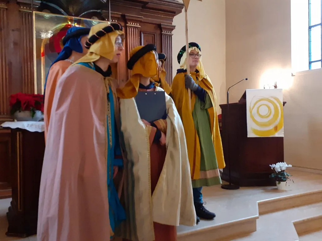 Als Könige verkleidete Kinder stehen vor dem Altar