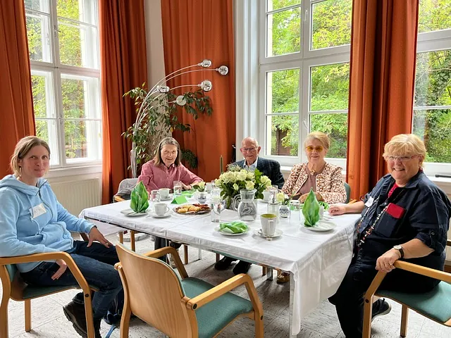 Personen sitzen um einen festlich gedeckten Tisch